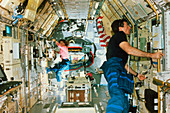 Astronauts working in a laboratory on the shuttle