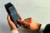 Man dialling a number into a cellular phone