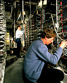 Technicians check telephone exchange equipment