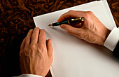 Businessman begins writing on a sheet of paper