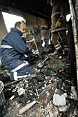 Firefighters in a burnt-out house