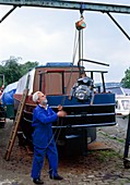 Engineer using block & tackle to lift boat engine