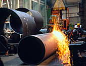 Man welding a boiler pipe with a welding machine
