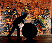 Silhouette of whisky worker rolling whisky cask
