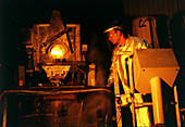 Foundrymen casting blocks of molten metal