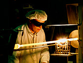 Worker making a glass blank for an optical fibre