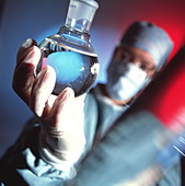 Chemist holding a round bottomed flask