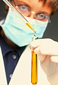 Female chemist using a pipette