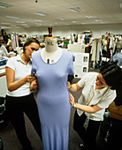 Clothing designers adjust the fit of a dress