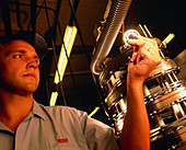 Worker visually inspecting a ball bearing