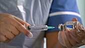 Nurse filling syringe