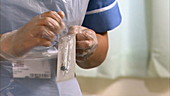 Nurse unwrapping syringe and needle