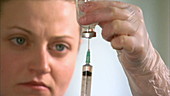 Nurse filling syringe with liquid