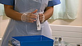 Nurse unwrapping syringe and needle