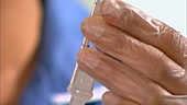 Nurse squeezing syringe