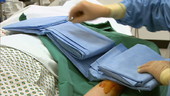 Doctor unfolding surgical sheet