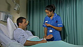 Nurse taking a patient's pulse