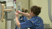 Nurse adjusting drip in hospital ward
