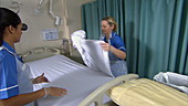 Nurses making hospital bed