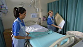 Nurses making hospital bed