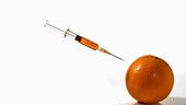 Syringe thrown into an orange