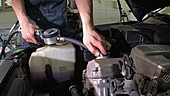 Mechanic filling an engine with oil