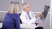 Male doctor discussing X-ray with patient