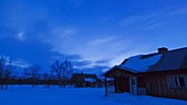 Aurora borealis over village, timelapse