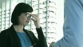 Woman choosing glasses at opticians