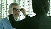 Man choosing glasses at opticians