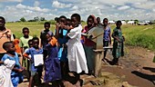 Children using a well pump, Malawi