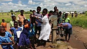 Children using a well pump, Malawi