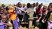 Children using a well pump, Malawi