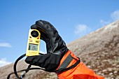 Mountaineer using an anemometer
