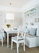 A white dining area in a country house-style with a comfortable bench and a wall shelf