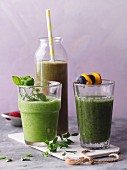 Three green smoothies garnished with chickweed and skewers