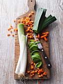 Sliced carrots and leek on a chopping board