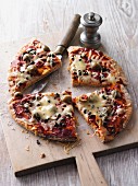 Wholemeal pizza with tomatoes, capers, anchovies, olives and Gouda