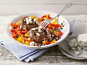 Meatballs with feta cheese on a pepper medley