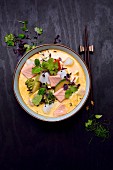Tom Kha Suppe mit Lachs, Kabeljau, Brokkoli, Zucchini, Koriandergrün und Sprossen (Thailand)