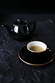 Kaffee in schwarzer Tasse und Kanne