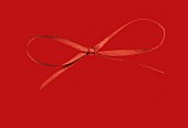 A red bow on a red surface