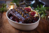 Studded roast venison with plums and lingonberry pears