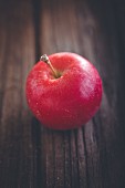 Roter Apfel auf Holzuntergrund