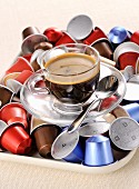 A cup of coffee and coffee capsules