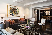 Zebra-skin rug in eclectic lounge area with dining area in background