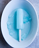 A blue ice lolly in a white bowl