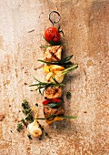 A meat kebab with vegetables and herbs