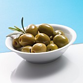Pitted green olives in a white bowl