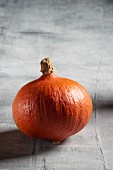 A Hokkaido pumpkin on grey surface